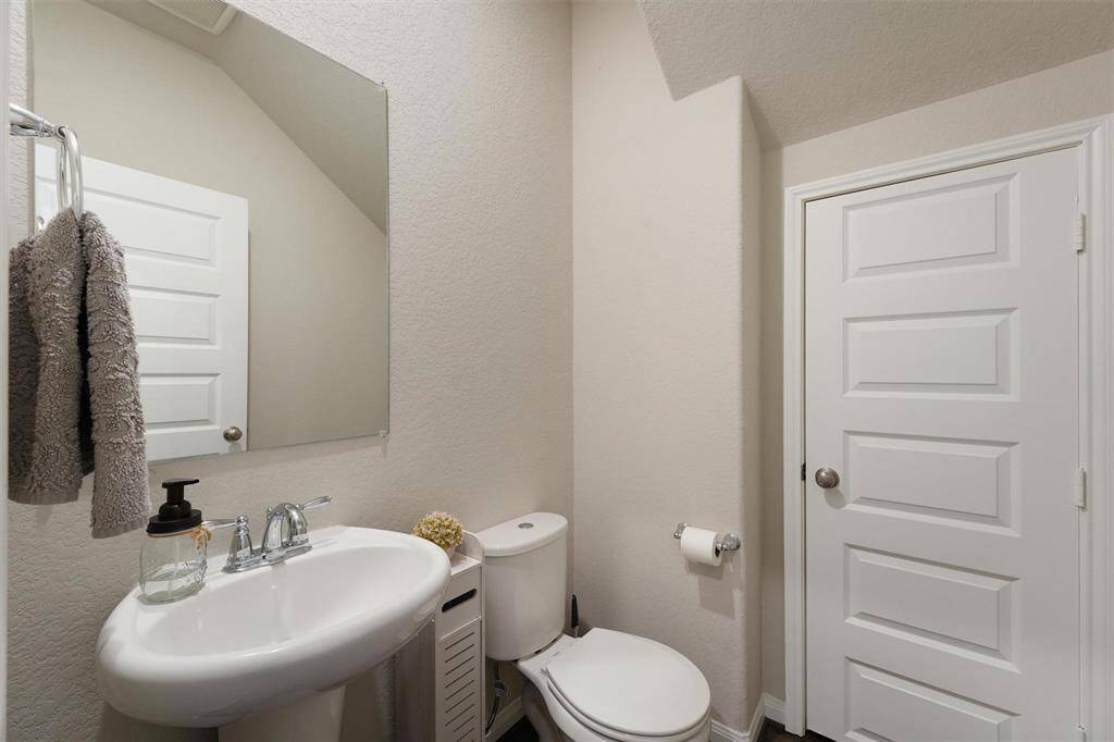 Half bath is conveniently located on the first floor and this door leads to an amazing under the stairs closet for bonus storage.
