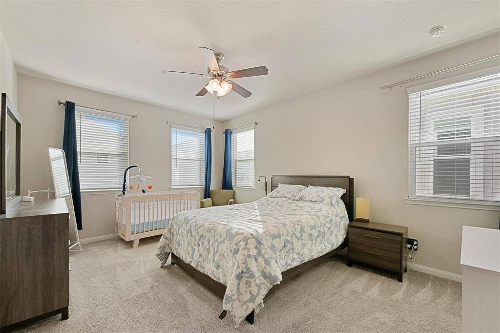 Cozy primary bedroom with large windows for plenty of natural light. This room easily accommodates kind sized furniture, dressers, a sitting nook, and room for a baby!