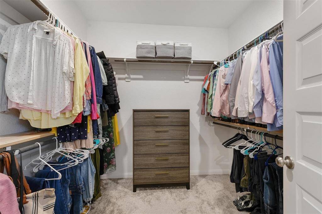 Large walk-in closet with built-in hanging space offering plenty of room for storage.