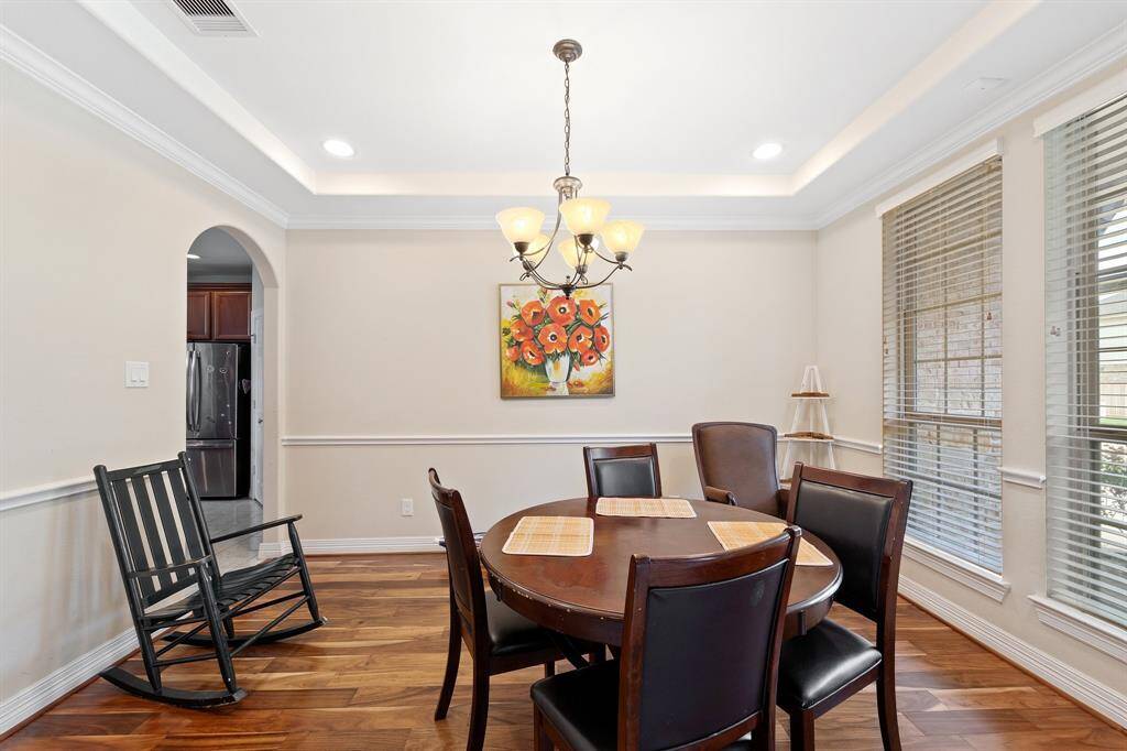 The formal dining room features elegant crown molding, abundant natural light, and space for hosting memorable gatherings.