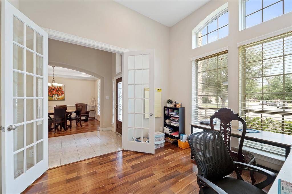 Glass French doors open to a private study just off the entryway, offering an ideal space for productivity or creativity.