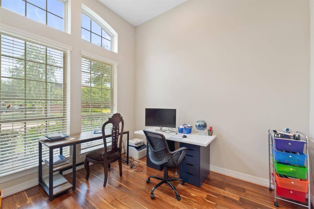 Bright and inviting study with soaring ceilings and large front-facing windows that fill the room with natural light—perfect for working from home.