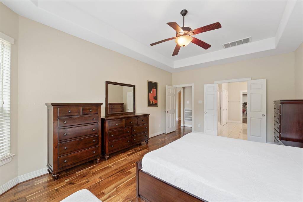 A generous layout connects the primary suite to the en-suite bath through double doors, with ample room for a full bedroom set.