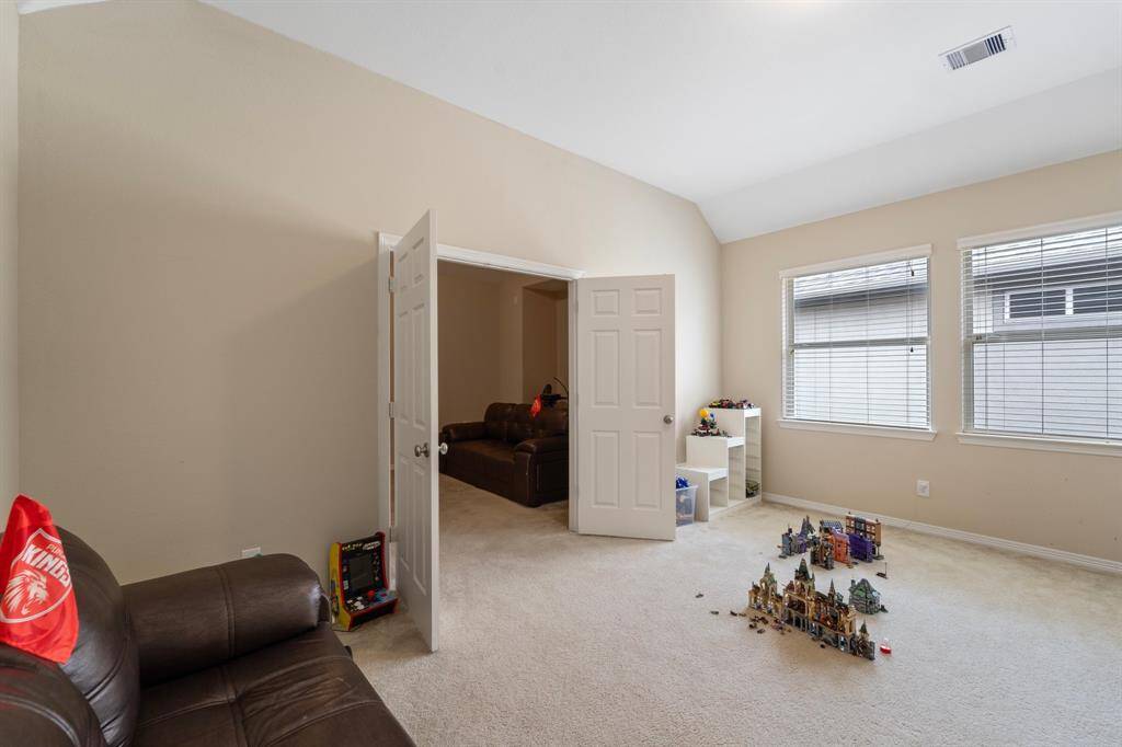 Light-filled game room with double doors opening to a private media space—ideal for play, relaxing, or entertaining.