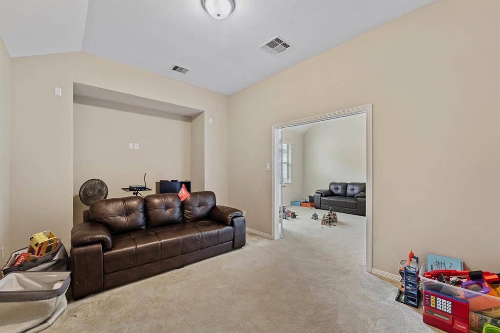 Cozy media room tucked behind double doors with a built-in niche for your home theater equipment, offering direct access to the adjoining game room.