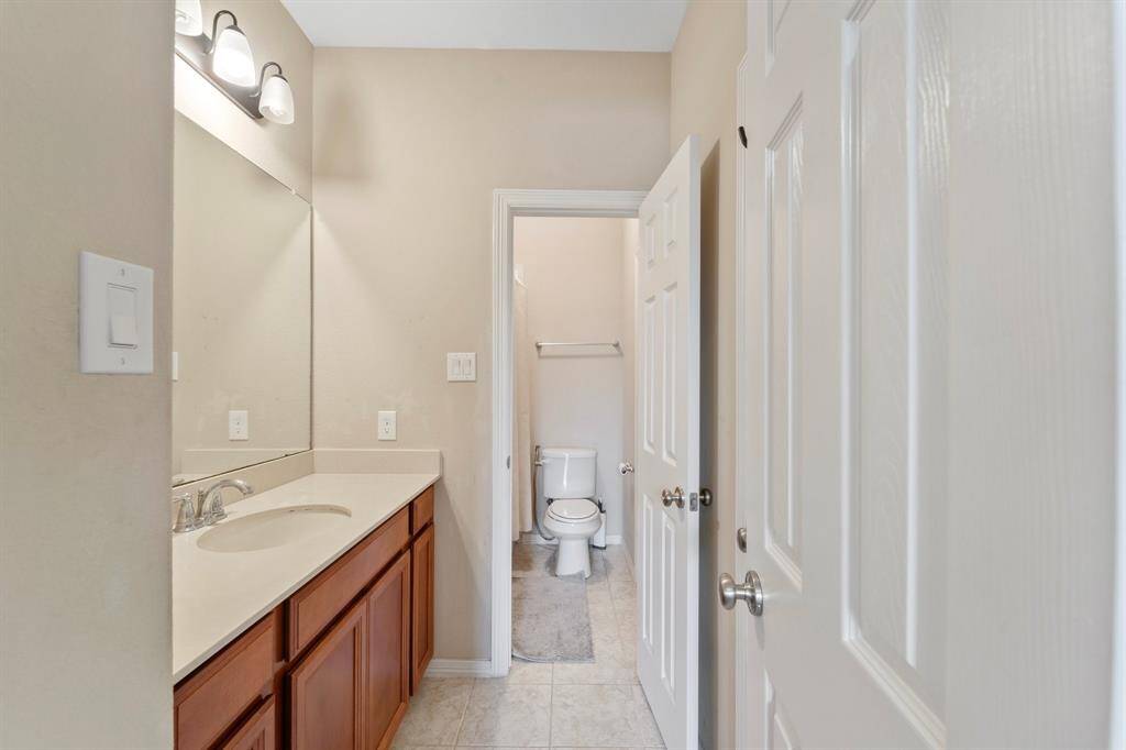 Sink with extended countertop and a private water closet with tub/shower combo connect two secondary bedrooms.