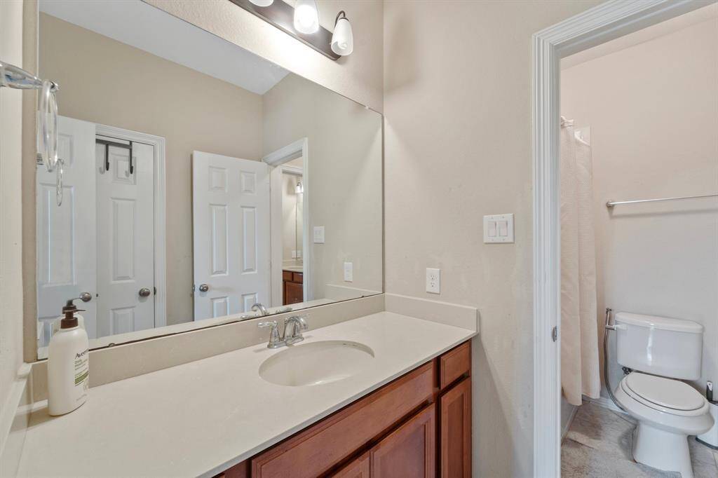 Large mirror and ample under-sink storage add to the room’s practicality.