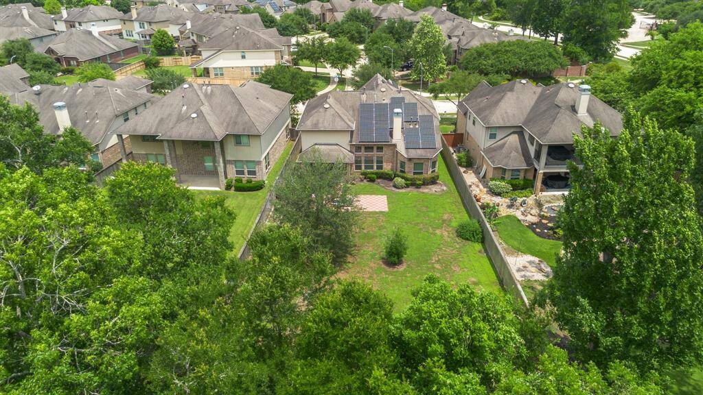 Bird's-eye view showcases the oversized lot with room to expand, garden, or relax under the shade of established trees.