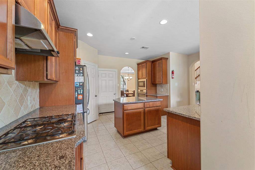 Spacious kitchen with granite countertops, gas cooktop, and a central island—perfect for meal prep and casual entertaining.