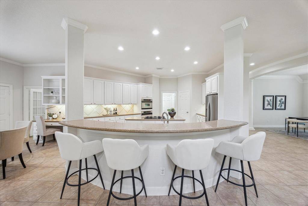 Bright and inviting kitchen with crisp white cabinetry, an oversized island with seating, and plenty of storage.