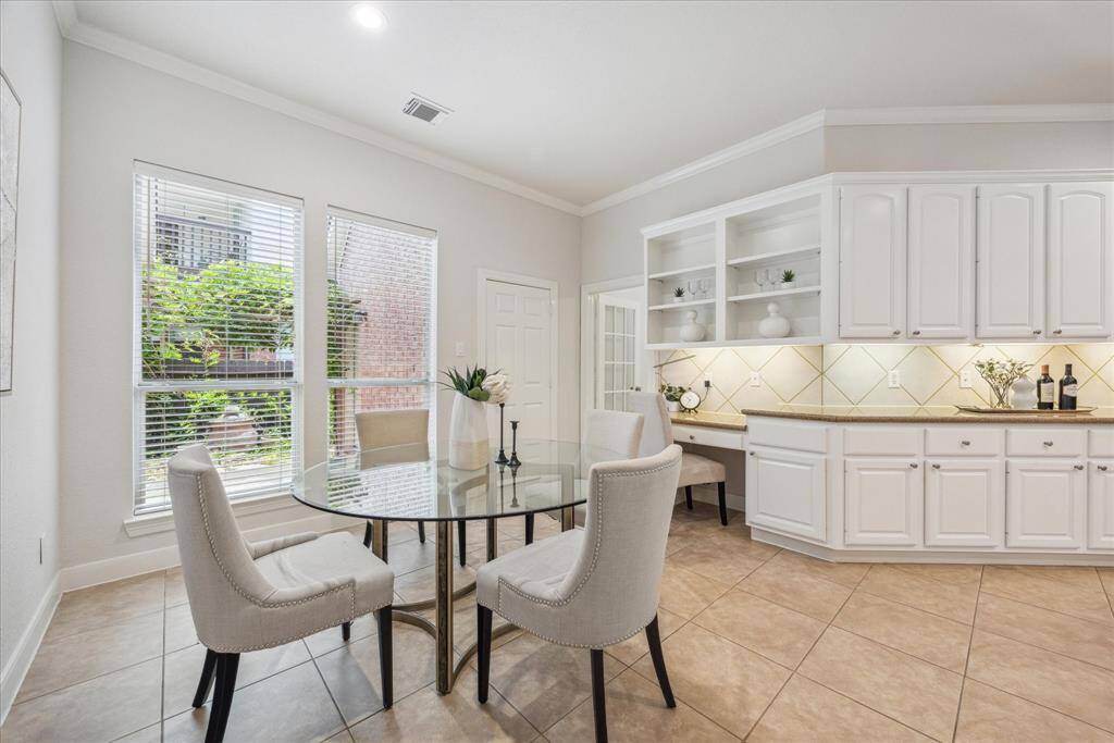 Light-filled breakfast area with views of the side yard, a built-in desk for added functionality, and a peek into the private study just off the kitchen.