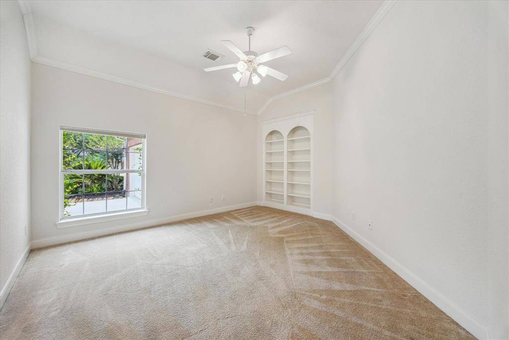 Spacious study with built-in bookshelves, offering a quiet and functional workspace just off the kitchen and breakfast area.
