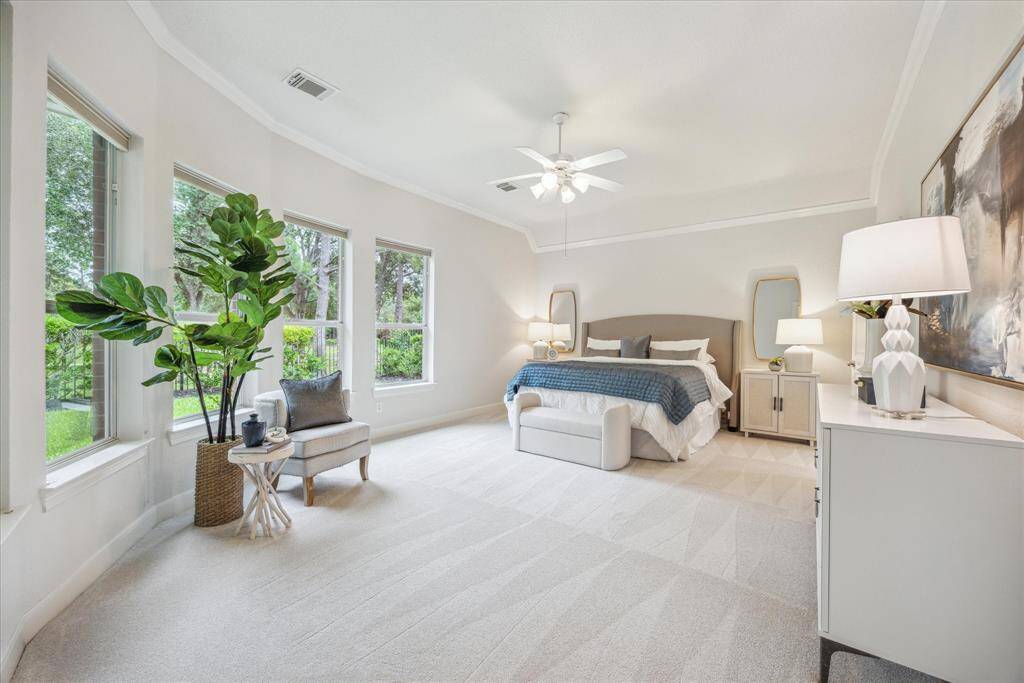 Spacious primary suite overlooking the backyard, featuring plush carpeting and a private en-suite bathroom for added comfort.