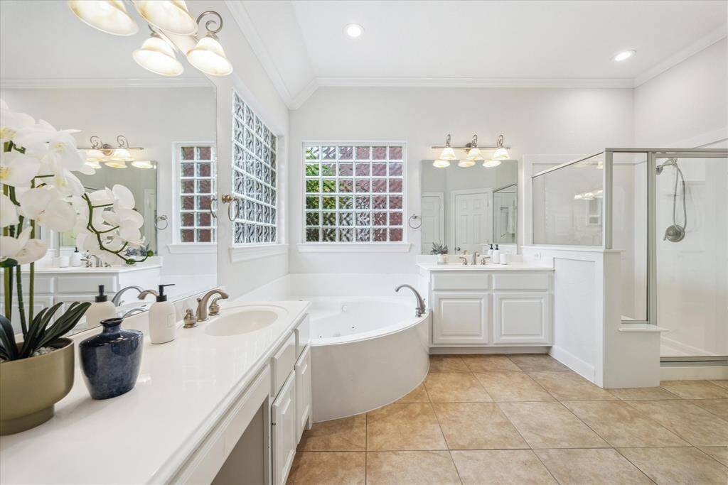 Primary bathroom with double vanities, a dedicated vanity area, soaking tub, and separate standing shower.