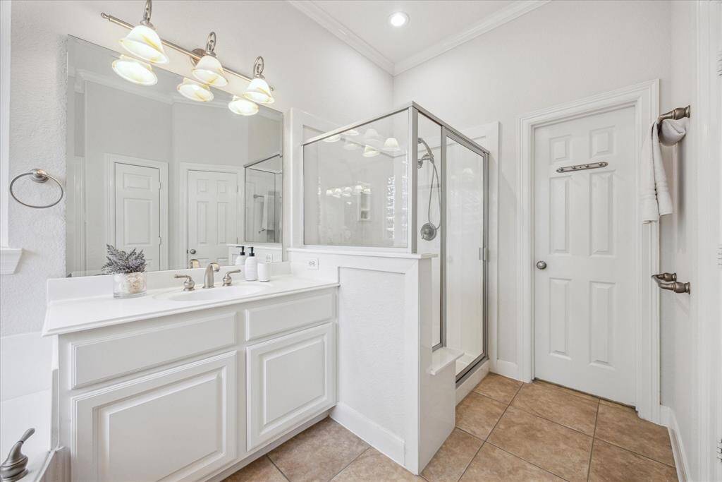 Primary bathroom includes access to large walk-in closet, providing ample storage space.