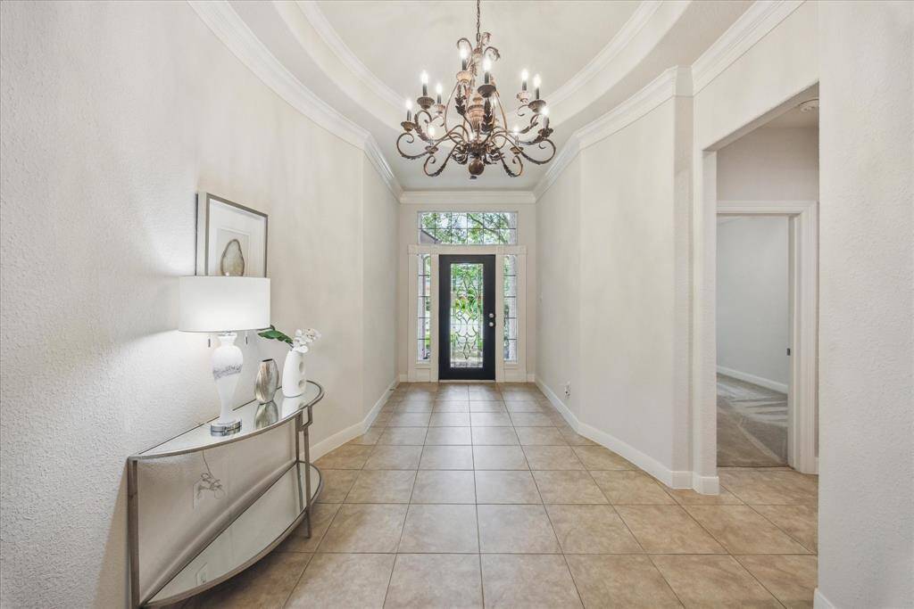 Spacious entry with an inviting flow, featuring one of four bedrooms located near the front of the home, ideal for guests.