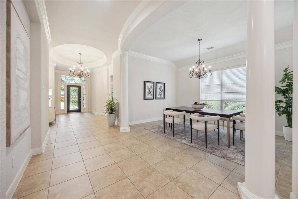 Elegant formal dining room with columns and a large window that fills the space with natural light, perfect for hosting gatherings.