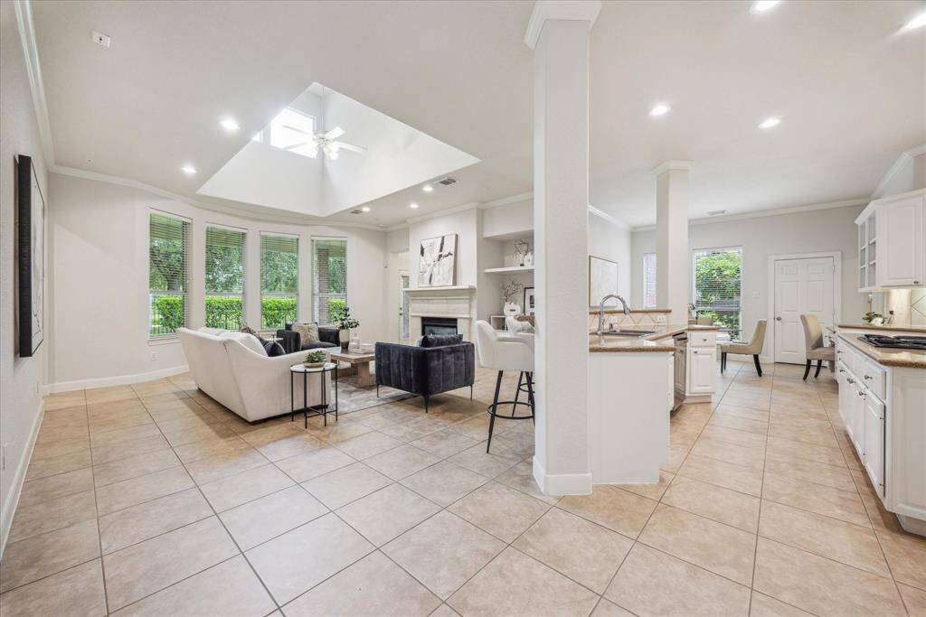 Bright and open family room featuring a cozy fireplace and a ceiling skylight that floods the space with natural light.