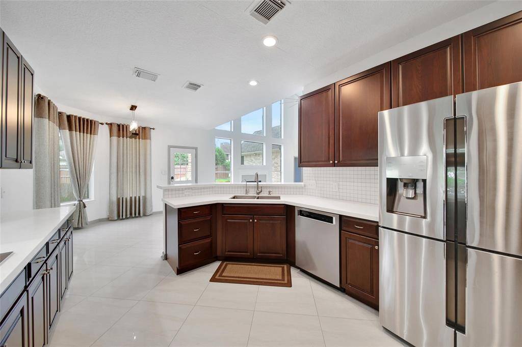 The kitchen boasts beautiful backyard views and stays connected with the living room for ease of entertaining and everyday enjoyment.