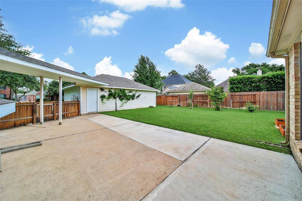There is a large patio for outdoor furniture and lounge chairs overlooking the lush lawn with fruit trees and a grape vine. The walkway to the three car garage is covered for all-weather protection.