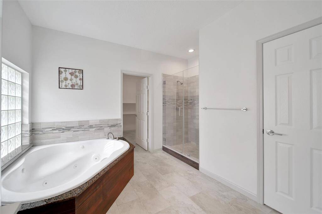 The over-sized jetted tub has a granite and mosaic surround and offers a tranquil space to unwind at the end of the day. There is also a frameless glass shower with travertine mosaics.