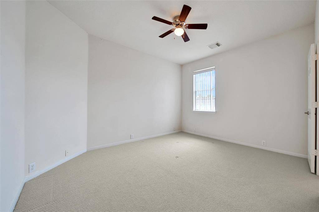 The back bedroom offers neutral paint and carpet, blinds and a ceiling fan for temperature control. It has a Jack and Jill bathroom attached to it.