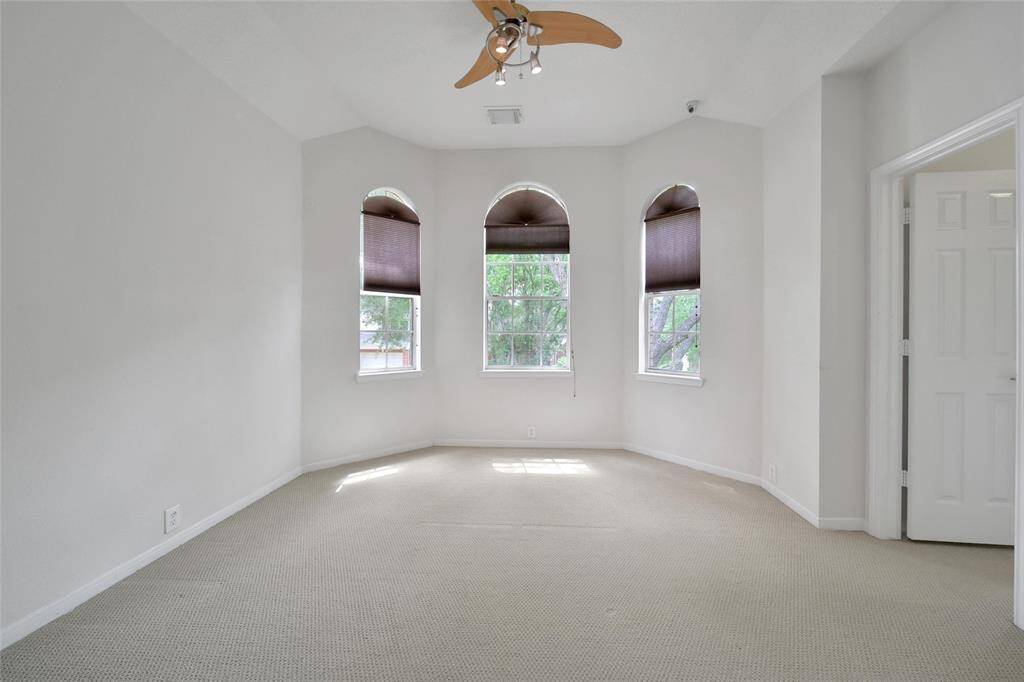 This beautiful secondary bedroom can be used as a guest suite with a massive walk-in closet and an en-suite bathroom. It The offers neutral paint and carpet, tree-lined views, blinds, and a ceiling fan for temperature control.