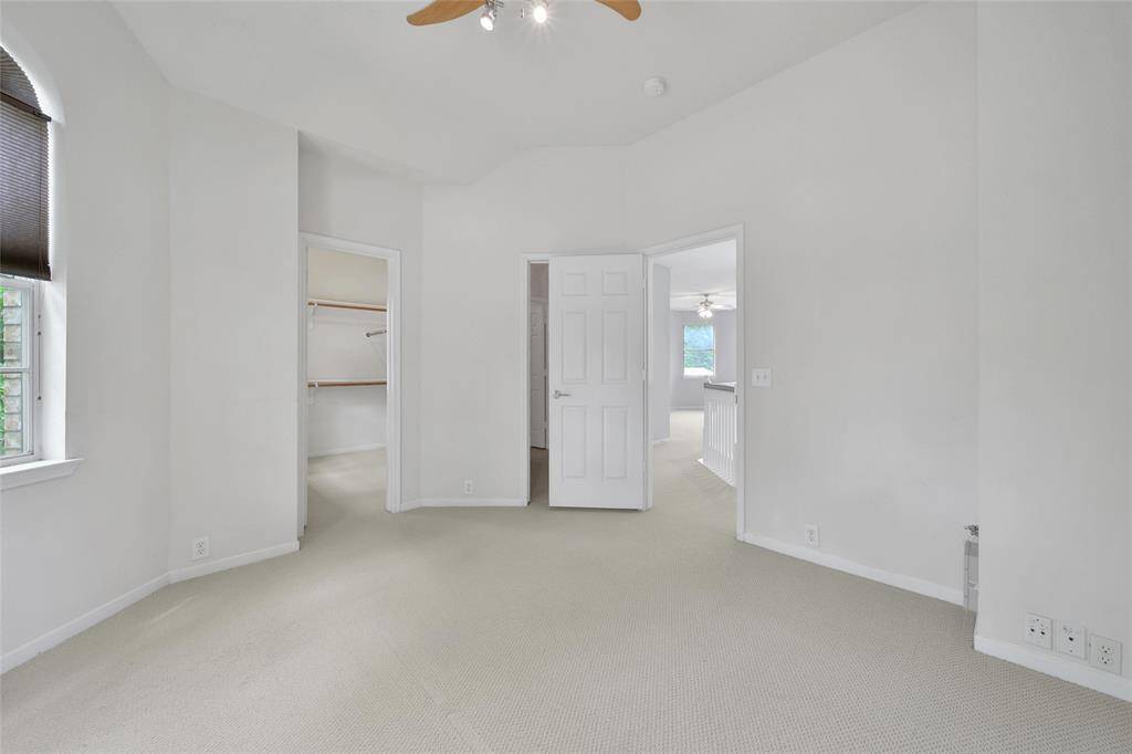 This beautiful secondary bedroom can be used as a guest suite with a massive walk-in closet and an en-suite bathroom. It The offers neutral paint and carpet, tree-lined views, blinds, and a ceiling fan for temperature control.