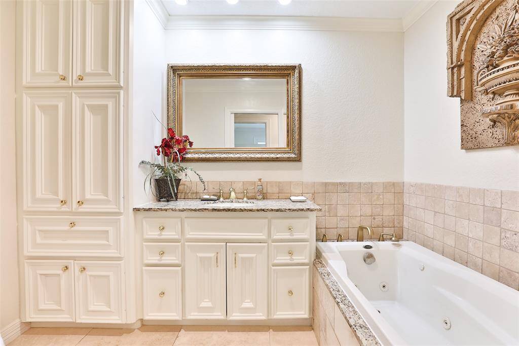 What an exquisite hall bath!  Your guests will love this!  Lots of cabinets and a built in hamper!