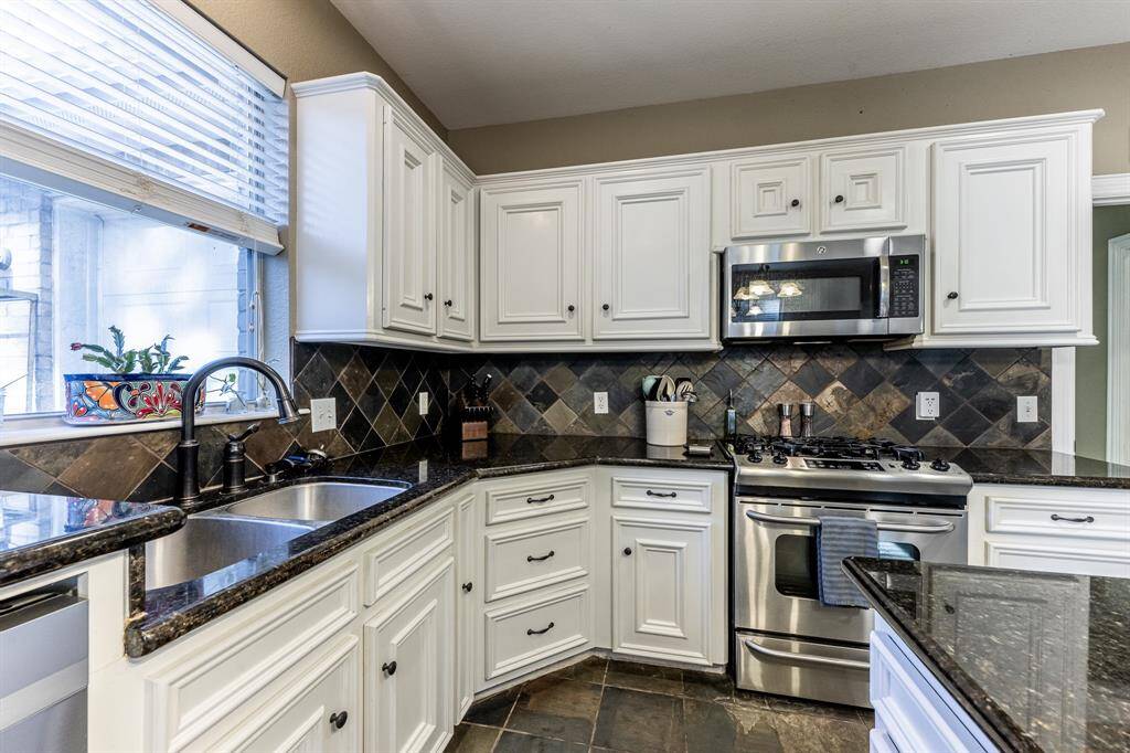 Sleek granite counters, stainless appliances, and crisp white cabinetry—this corner of the kitchen is all about form, function, and a little everyday luxury.