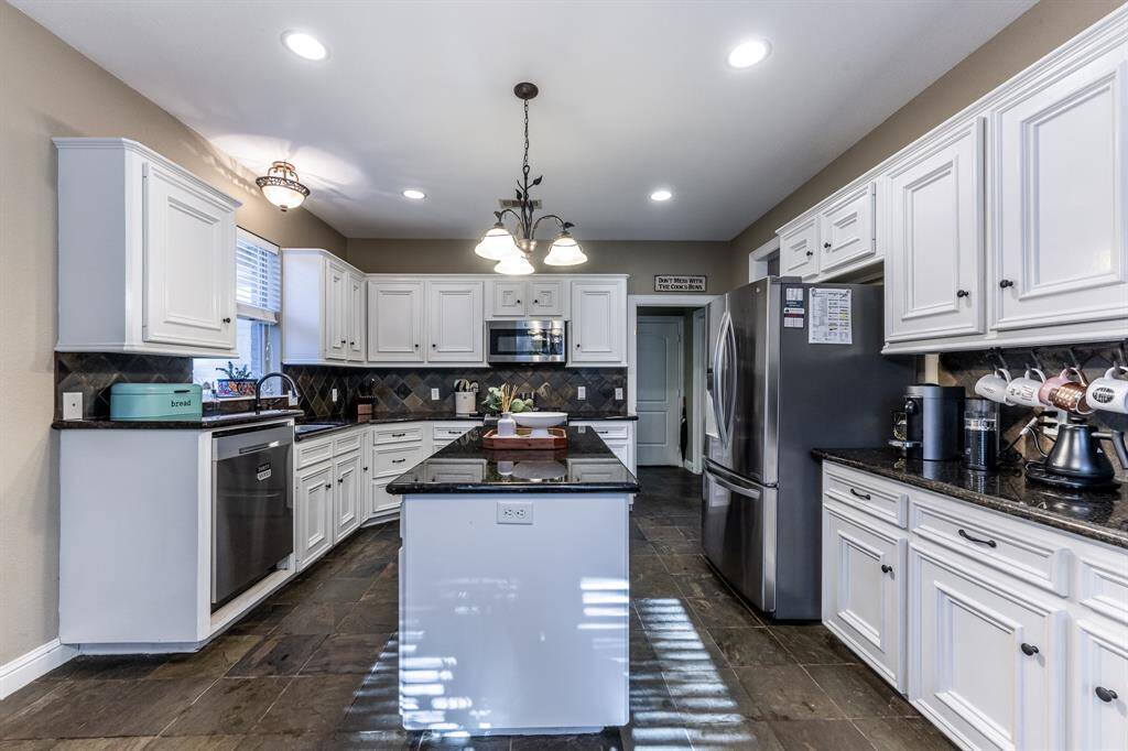 All the storage, all the style—this kitchen delivers with white cabinetry, granite counters, and a central island ready to handle everything from meal prep to mingling.
