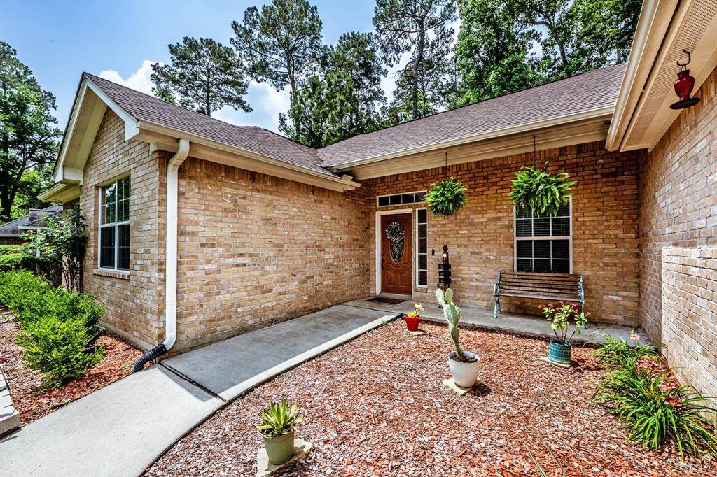 Welcome vibes start here—this inviting walkway and covered porch set the tone with brick charm, pops of greenery, and just the right amount of “you’re home.”
