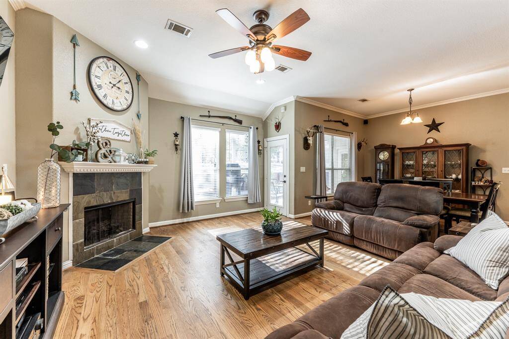 Cozy and bright with real hardwood flooring, a corner fireplace with slate surround, and tons of natural light pouring in—this space has all the right vibes for relaxing or entertaining.
