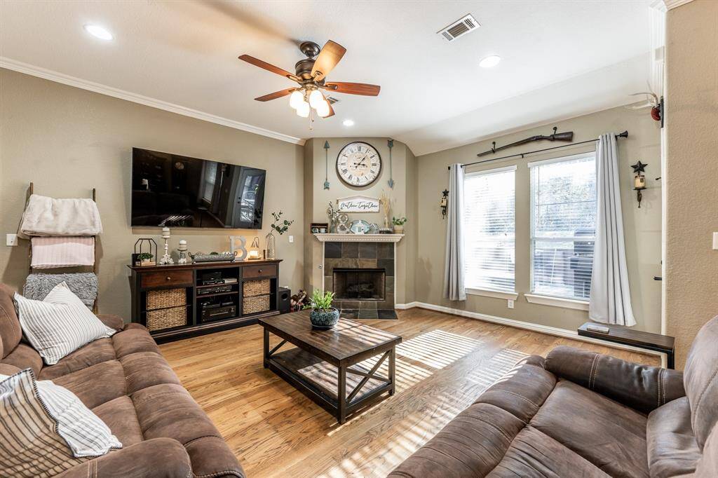 Light, bright, and ready for good times—this living room brings the charm with real hardwood floors, a slate-accented fireplace, and plenty of sunshine to keep things cheerful.