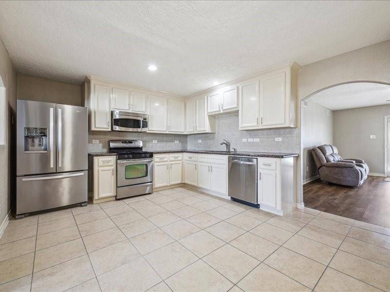 The open and spacious kitchen features stainless steel appliances and granite countertops.