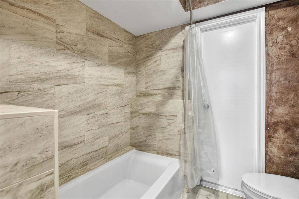 Another view of primary bath with door to storage area