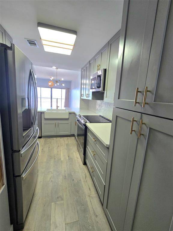 Thoughtfully remodeled to maximize functionality, this kitchen features a pantry cabinet and open shelving—offering impressive storage solutions within a compact footprint.