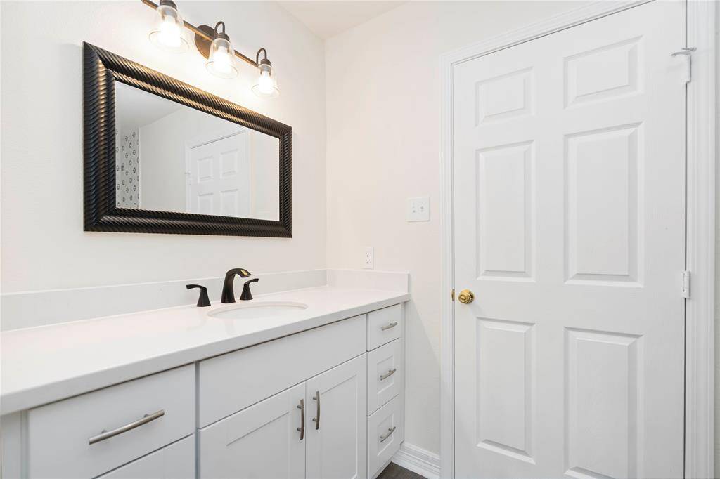 Stylish secondary bathroom vanity with ample storage and elegant fixtures.