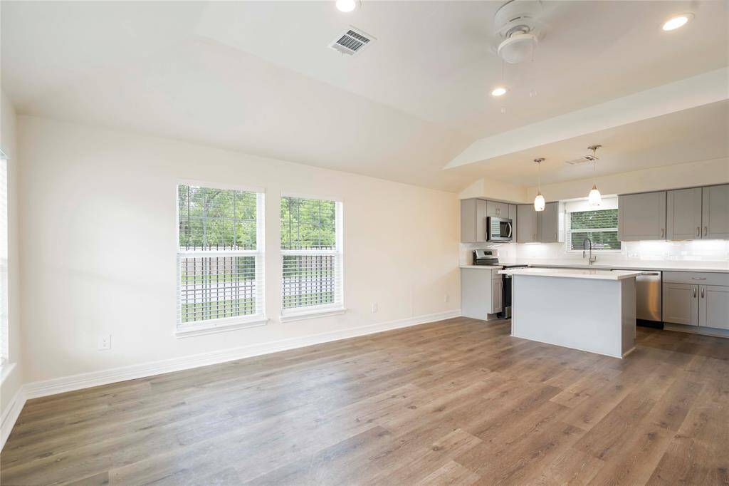 Bright and inviting living area with an open layout, seamlessly connecting to a modern kitchen. Abundant natural light and elegant finishes create a perfect space for relaxation and entertaining.