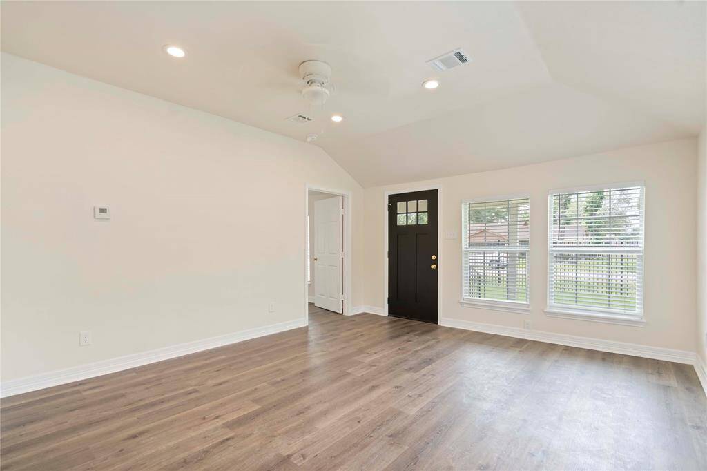 Step into a bright, spacious living room featuring elegant hardwood floors and abundant natural light from large windows. Perfect for relaxing or entertaining.