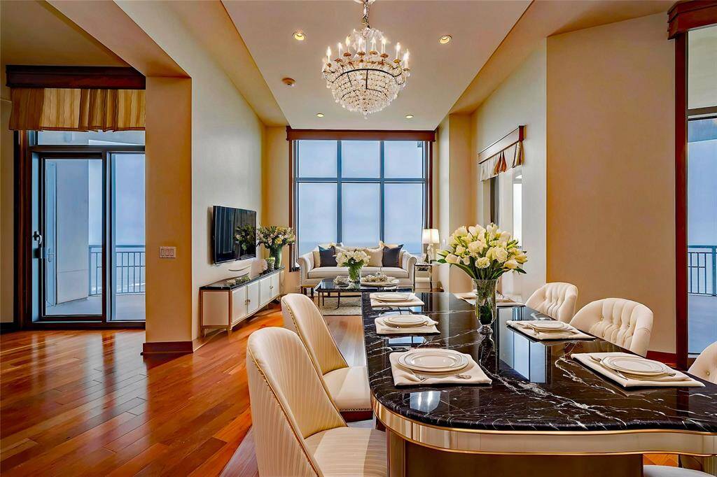 The dining area, next to the living space, features a large picture window, balcony access, and stunning gulf views.(AI photo)