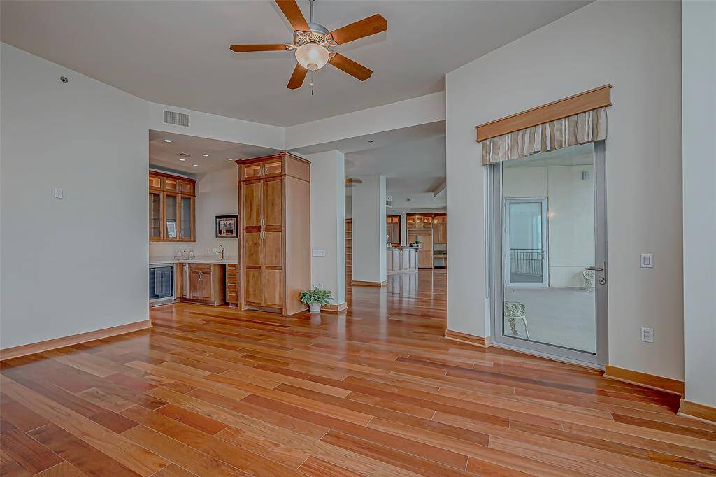 Discover an inviting bar area complete with a mini refrigerator, wine fridge, sink, and ample storage—perfect for entertaining guests in style.