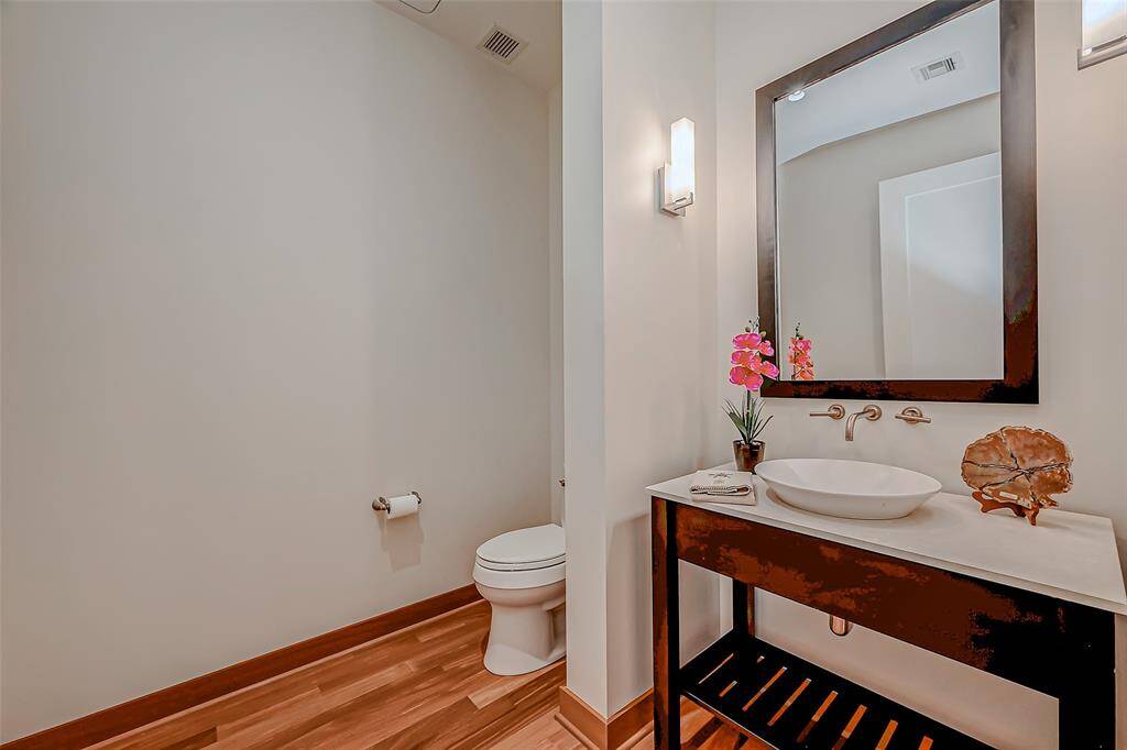 Elegant half bath off the den, featuring stylish lighting and fixtures—perfect for guests.
