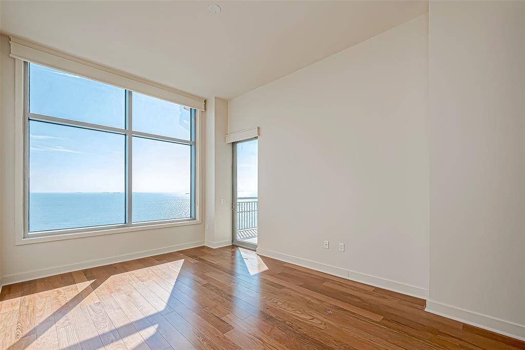 Spacious secondary bedroom with potential as a second master. Enjoy balcony access, custom wood cornice boards, and roll-up room darkening shades. Revel in stunning views through a large picture window and private balcony.