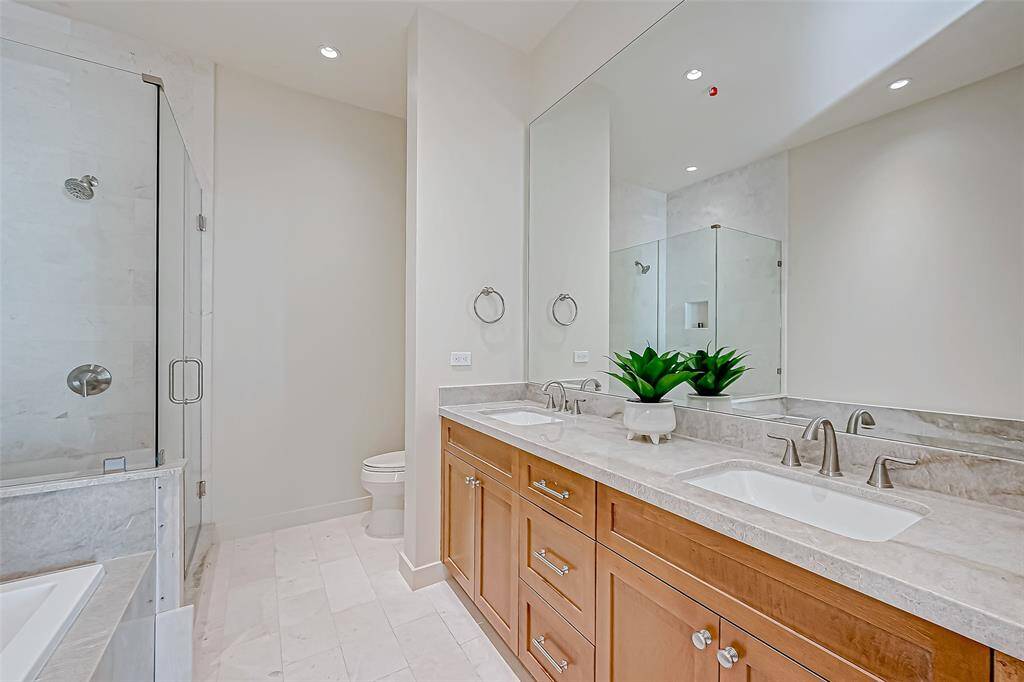 Spacious master bath featuring custom flooring, elegant countertops, and enhanced lighting.