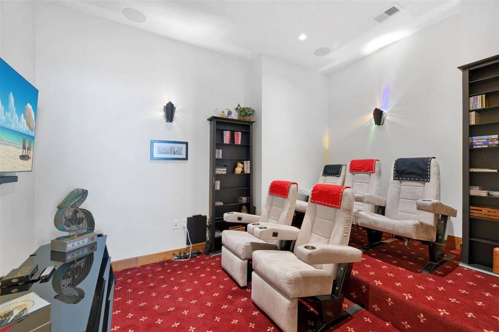 Experience cinematic comfort in this multi-level media room, featuring plush seating and immersive surround sound—perfect for relaxing after a day at the beach.