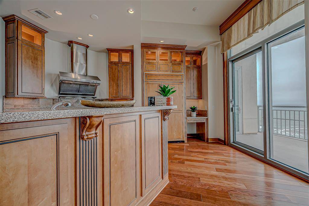 Experience culinary luxury in this chef’s kitchen, featuring a paneled Sub-Zero refrigerator, gas range, custom cabinetry, and granite countertops. Enjoy stunning beach views and custom lighting throughout with floor to ceiling windows.