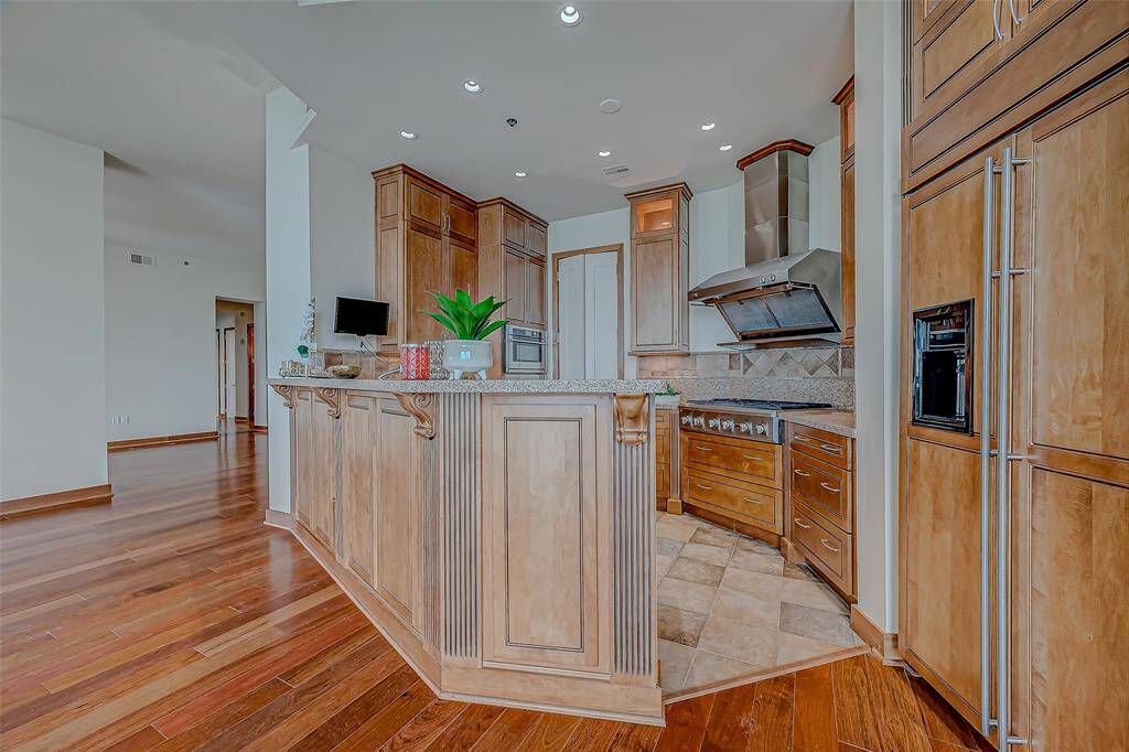 The kitchen has trim paneled subzero refrigerator, GAS range, custom cabinetry with pull out drawers and a walk-in pantry.  There is lots of natural light in this great floorplan.