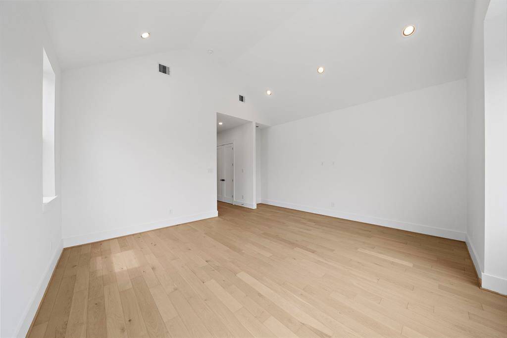 Alternate view of the spacious primary bedroom with beautiful wood flooring. (Photo is of a previously completed home.)