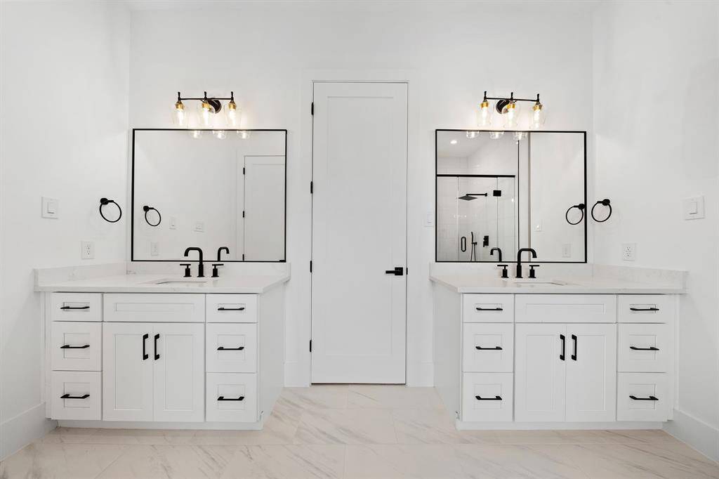 Dual vanities with quartz counters, designer fixtures, and black matte hardware. (Photo is of a previously completed home.)